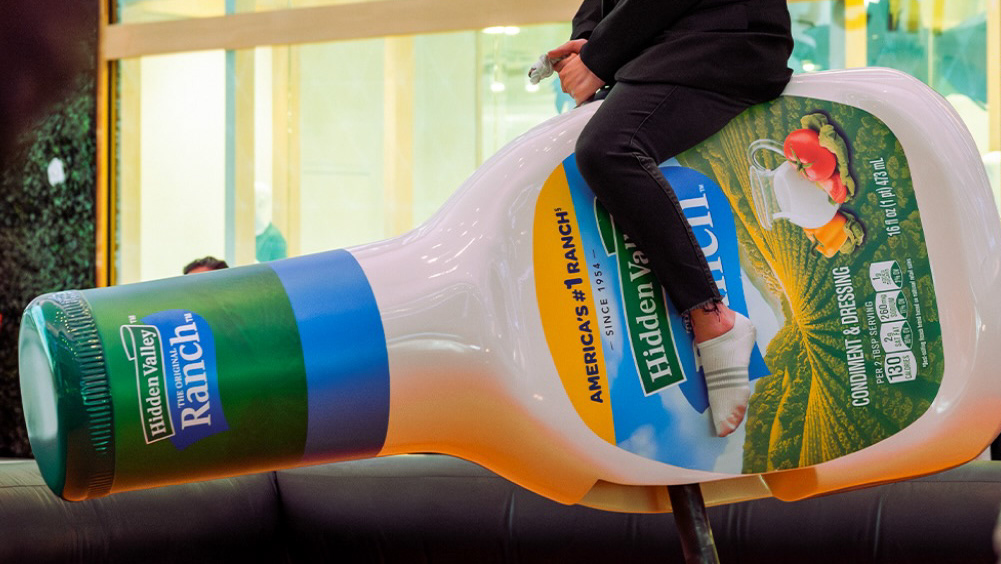Guest riding a custom mechanical Hidden Valley Ranch bottle