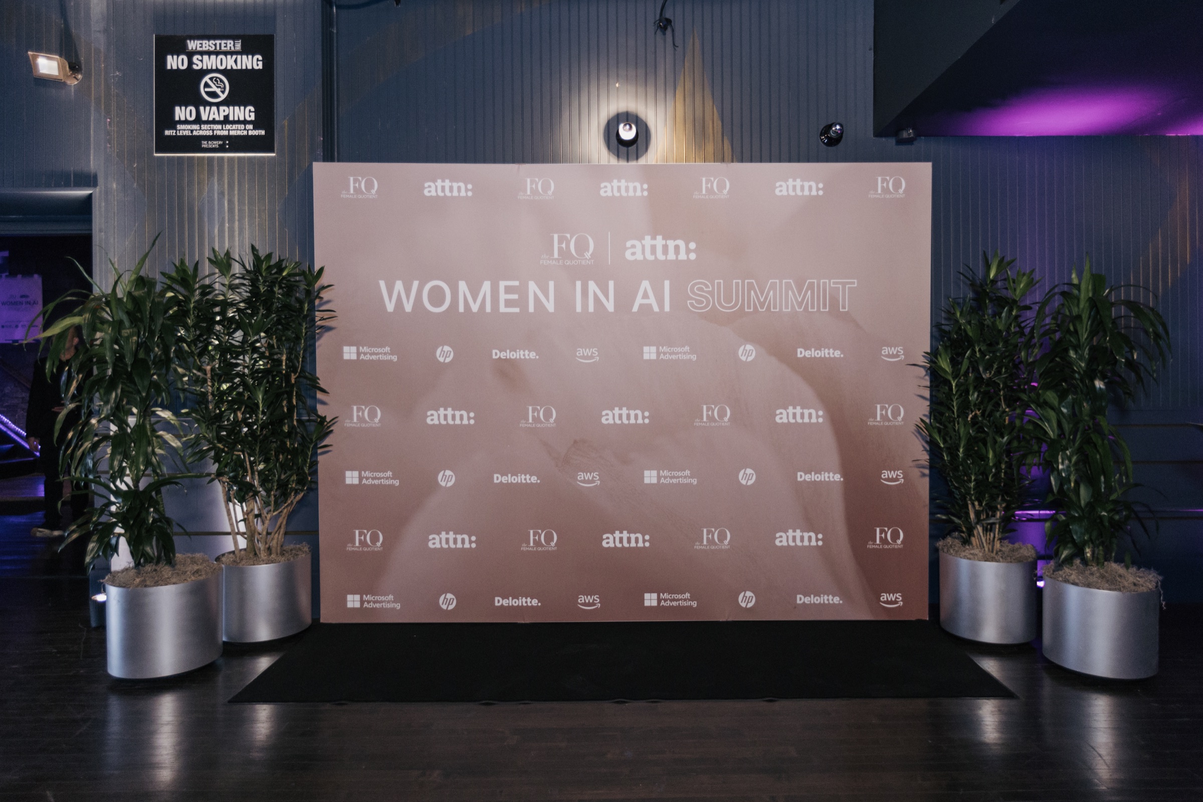 Rose Women in AI Summit step-and-repeat framed by greenery