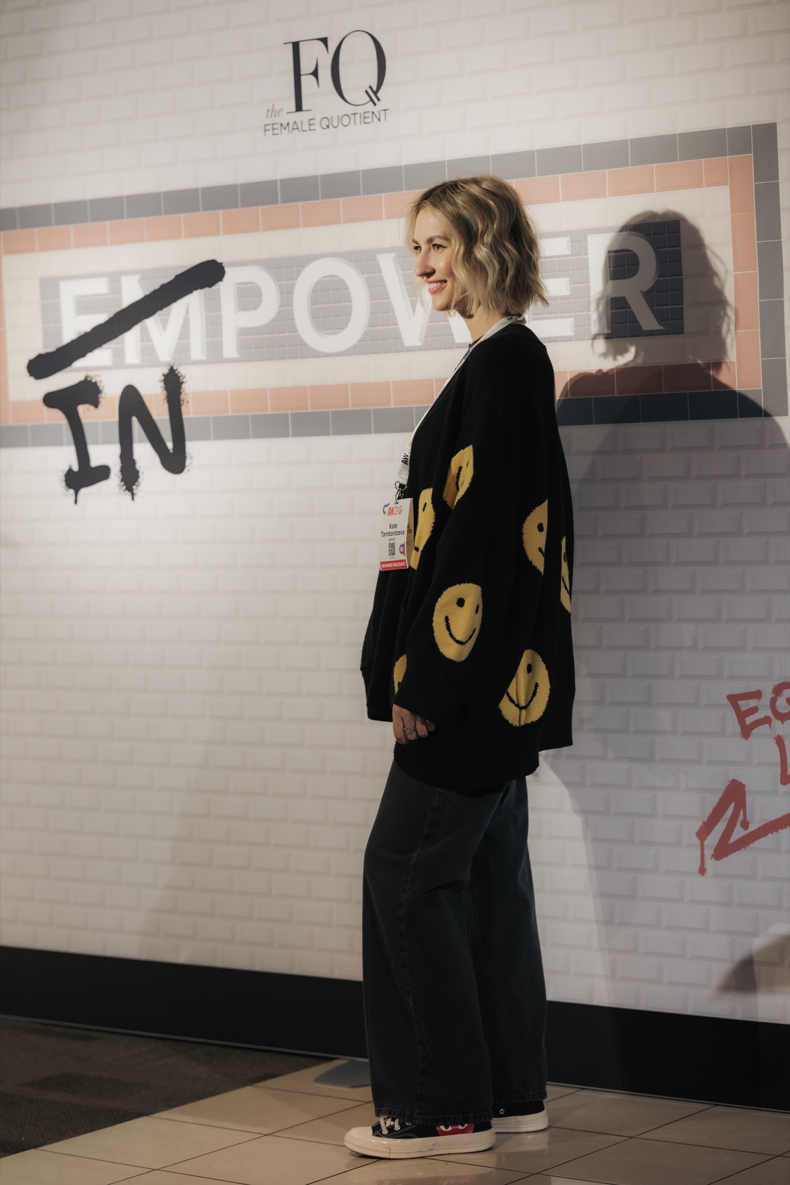 Guest posing in front of the In Power subway-inspired photo wall