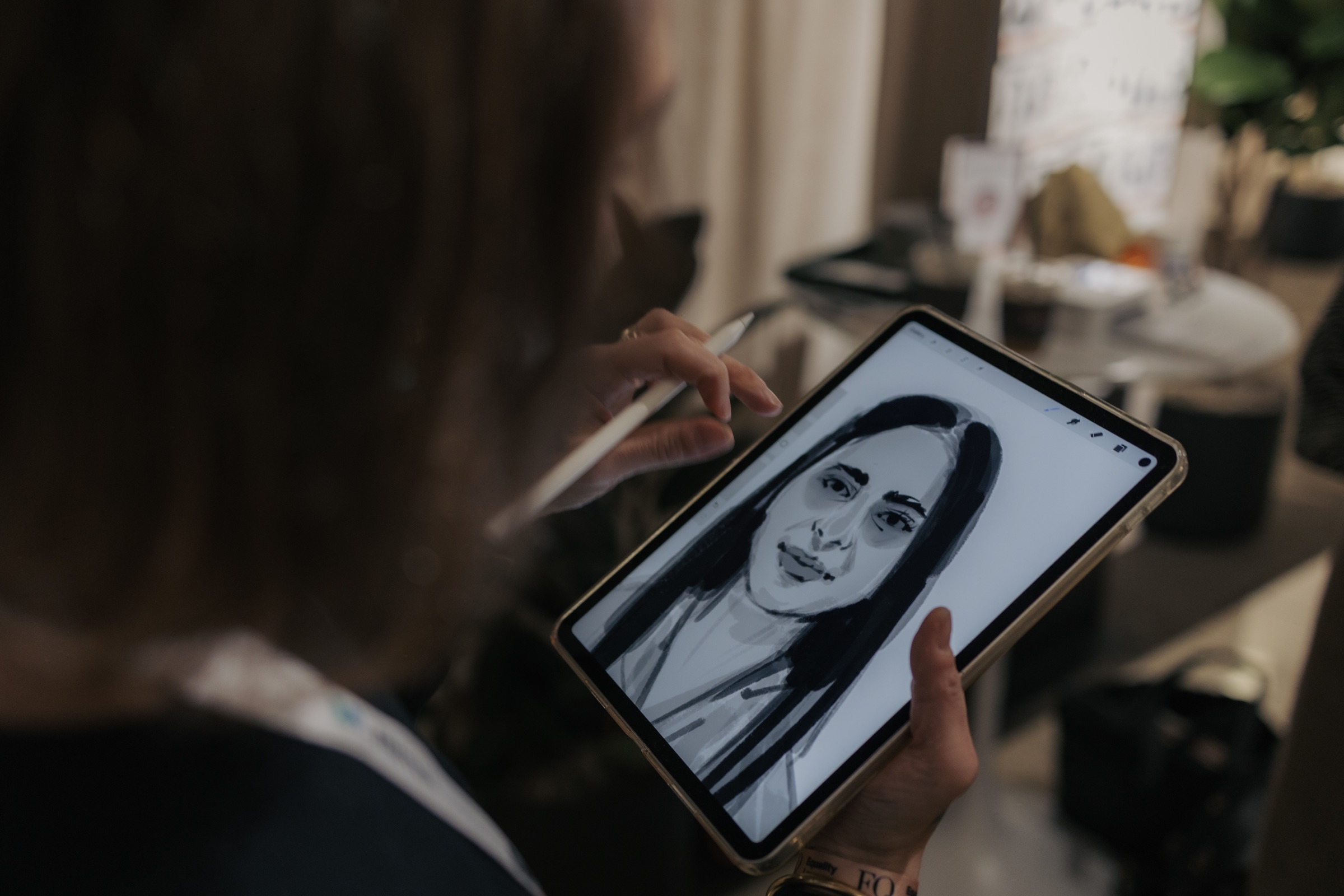 Guest holding a live fashion sketch displayed on an iPad