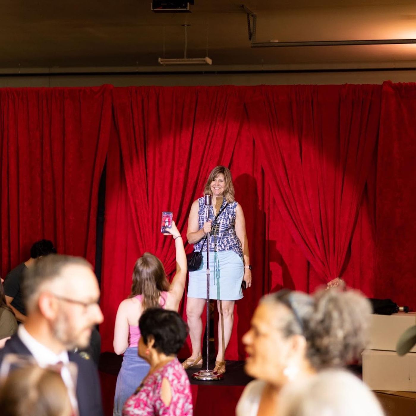 Fan at the vintage microphone on the museum's red-velvet performance stage