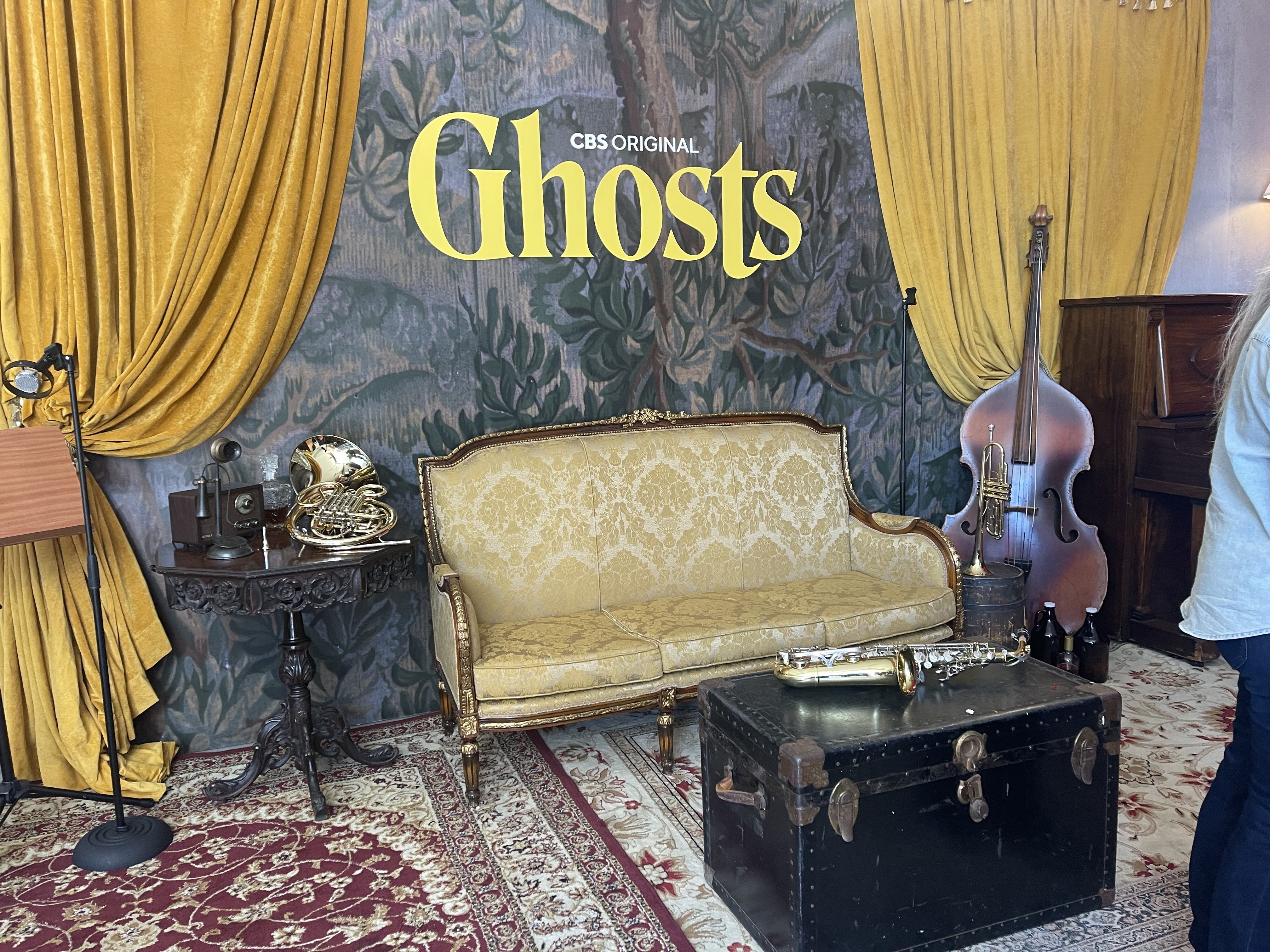 Gold-curtained jazz stage with Ghosts backdrop, antique settee and instruments