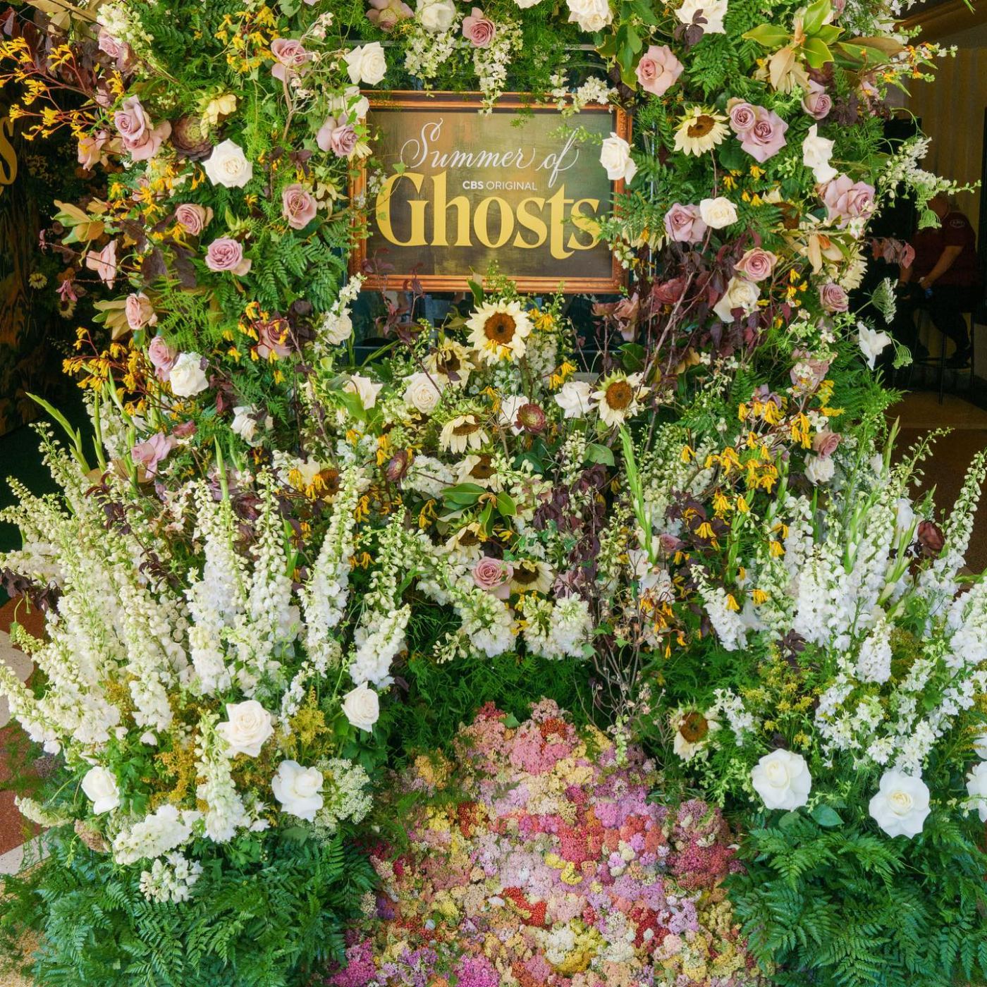 Summer of Ghosts framed logo nested in a floral installation at the FYC event
