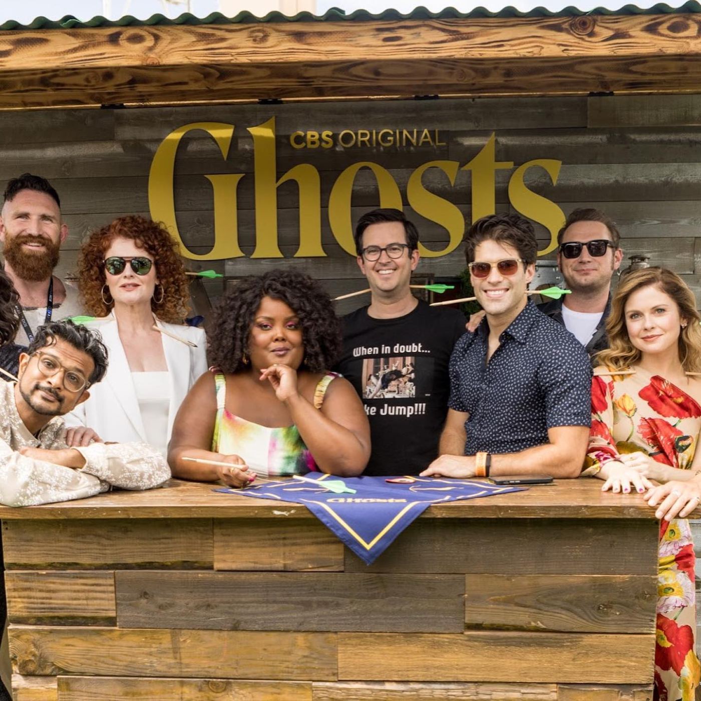 The cast of Ghosts behind the campground popcorn stand, arrows through their hats