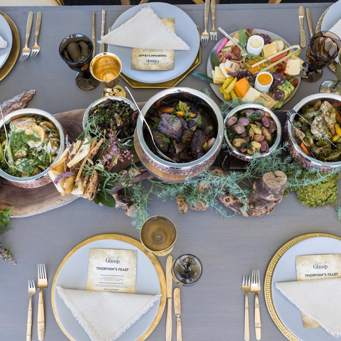 Thorfinn's Feast tablescape with copper cauldrons, golden goblets and parchment menus
