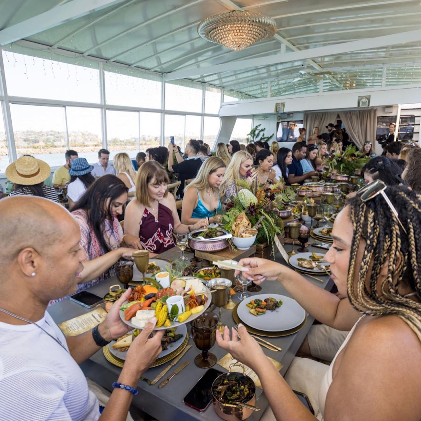 Influencer guests feasting family-style aboard the yacht