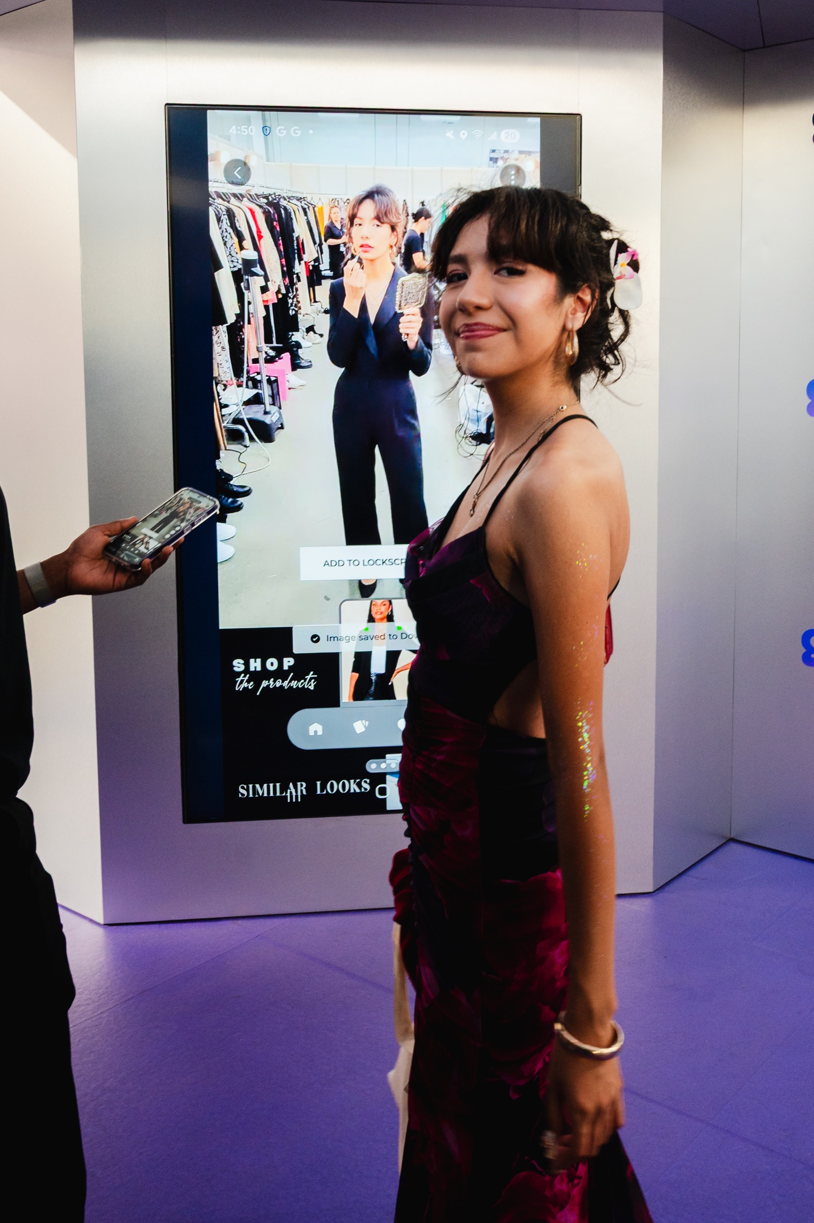 A guest posing beside her portrait on the Glance AI styling screen