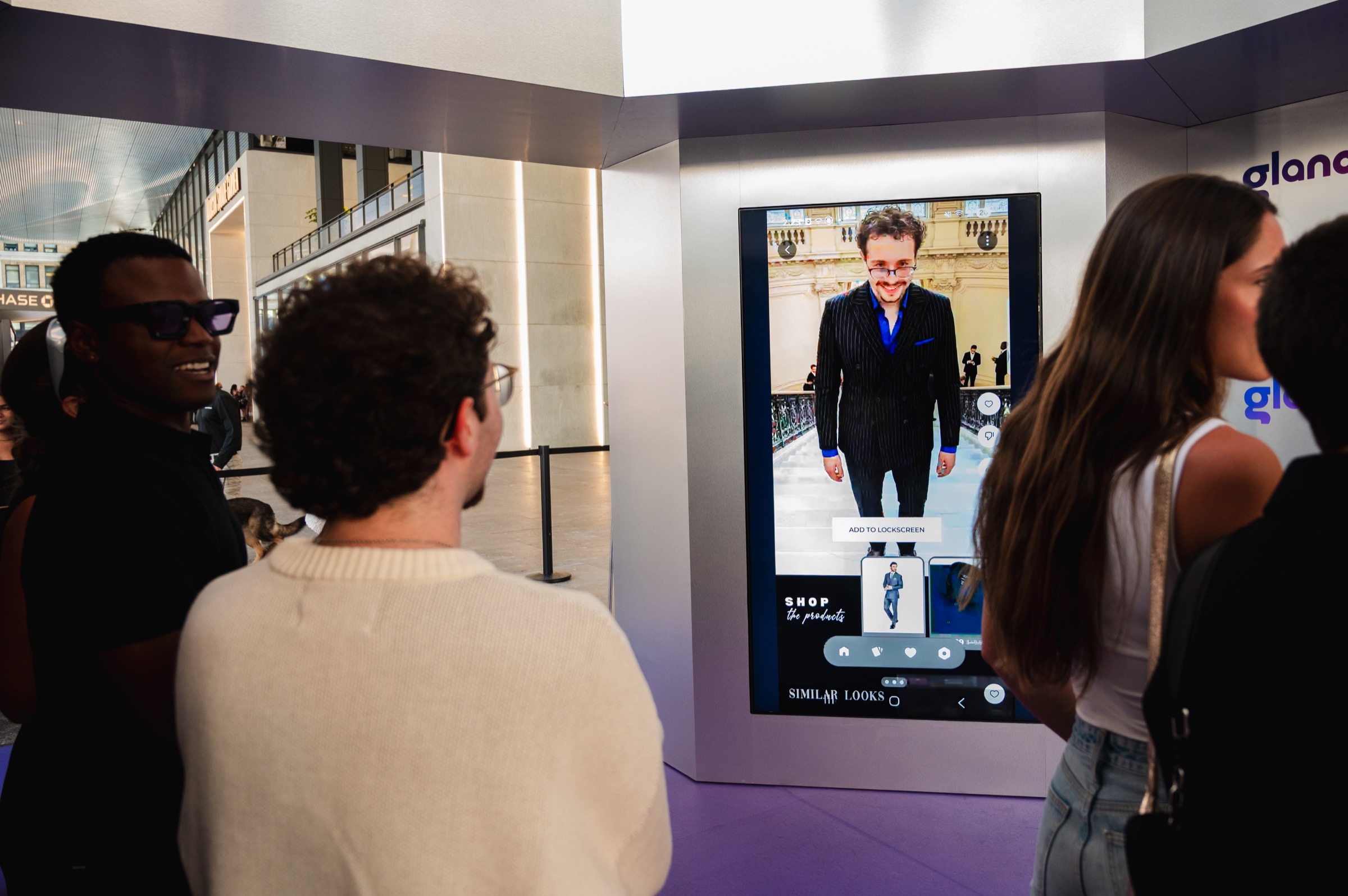Guests reviewing personalized AI fashion looks on the Glance screen