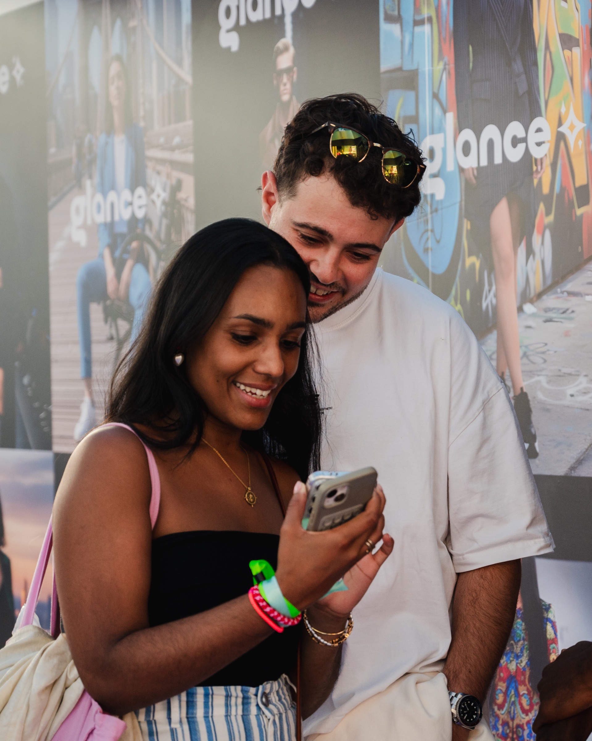 Two guests sharing their Glance AI result on a phone