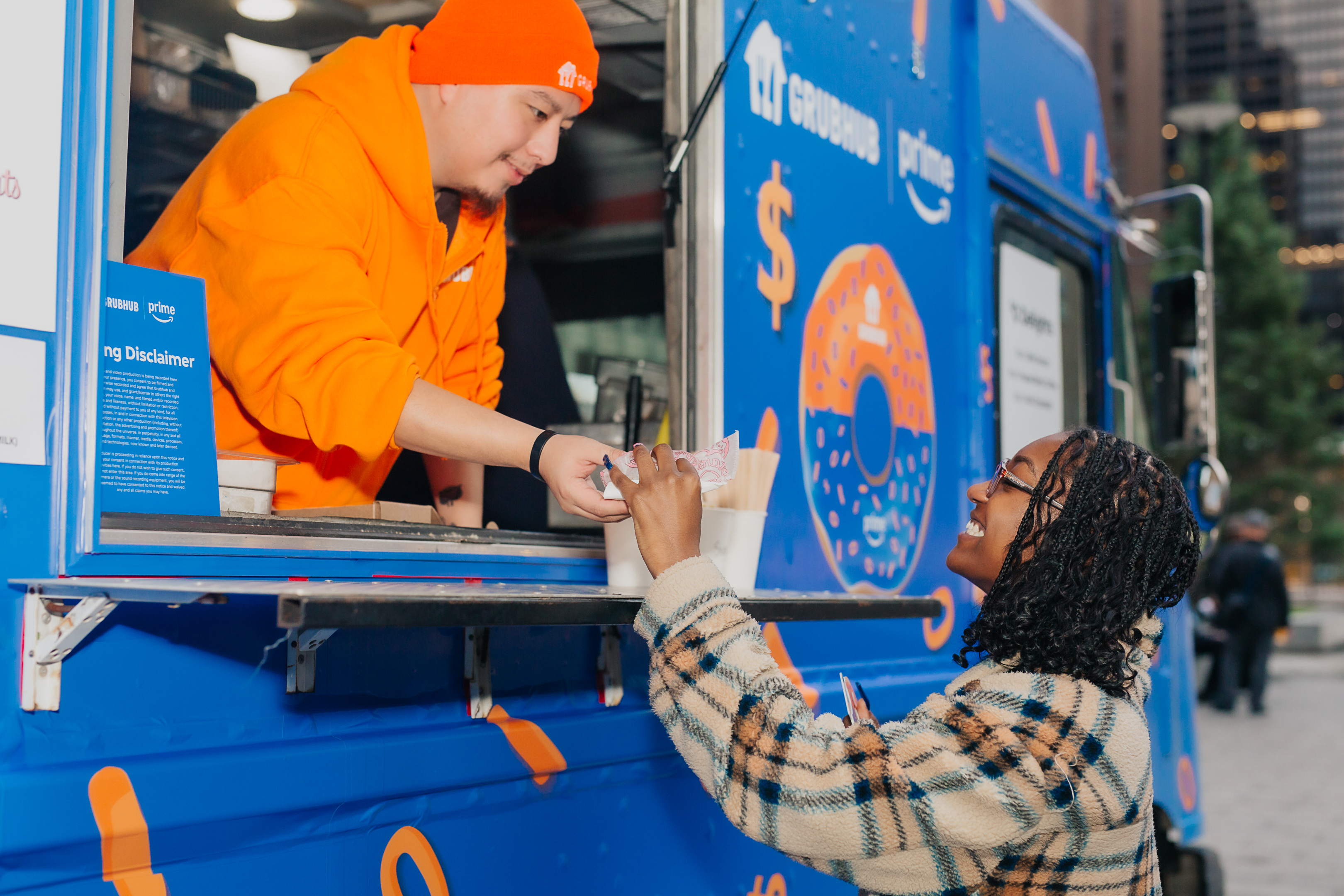 Brand Ambassador handing a treat to a smiling guest at the truck window