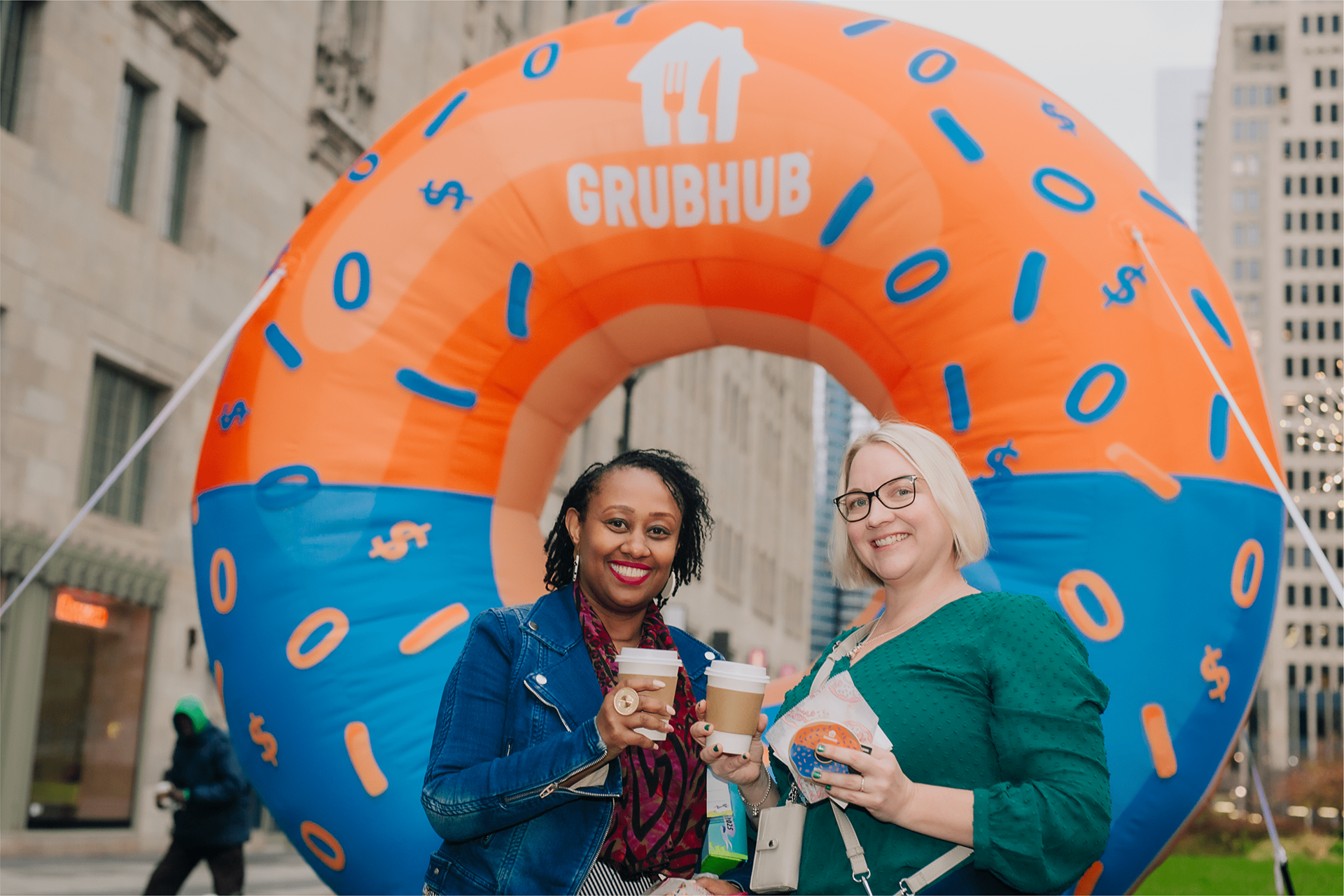 Guests posing with coffee inside the giant inflatable GrubHub donut