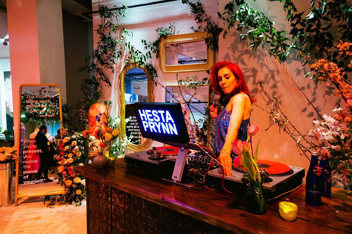 Project Bloom opening-night DJ surrounded by florals, mirrors and warm light