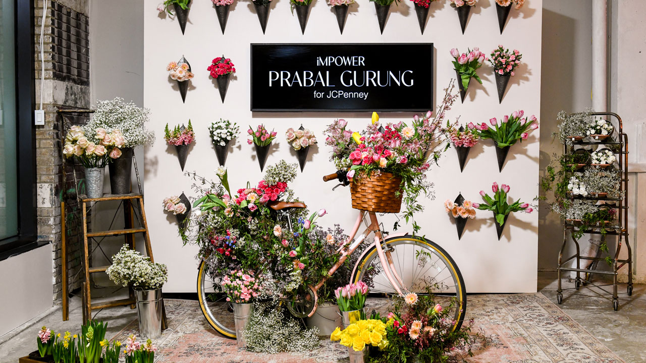 Floral bicycle installation in front of the iMPOWER Prabal Gurung photo wall