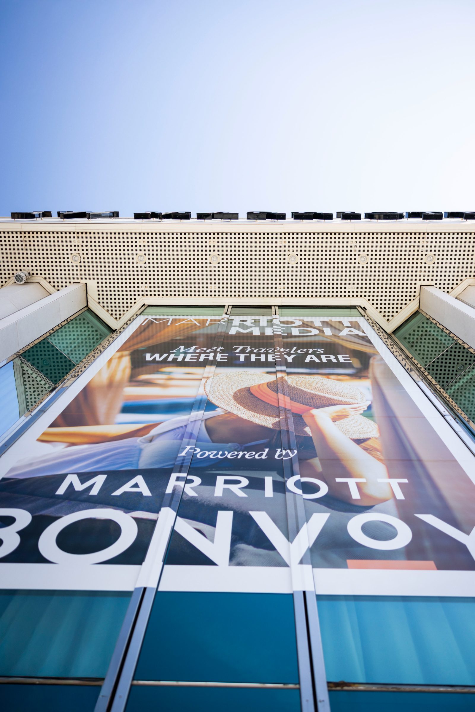 Looking up at the Marriott Media banner rising over the JW Marriott Cannes entrance