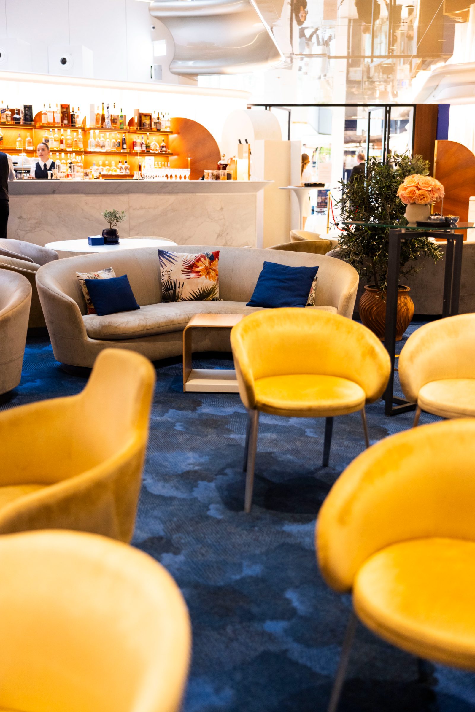 Yellow velvet chairs and the marble bar inside The Lounge