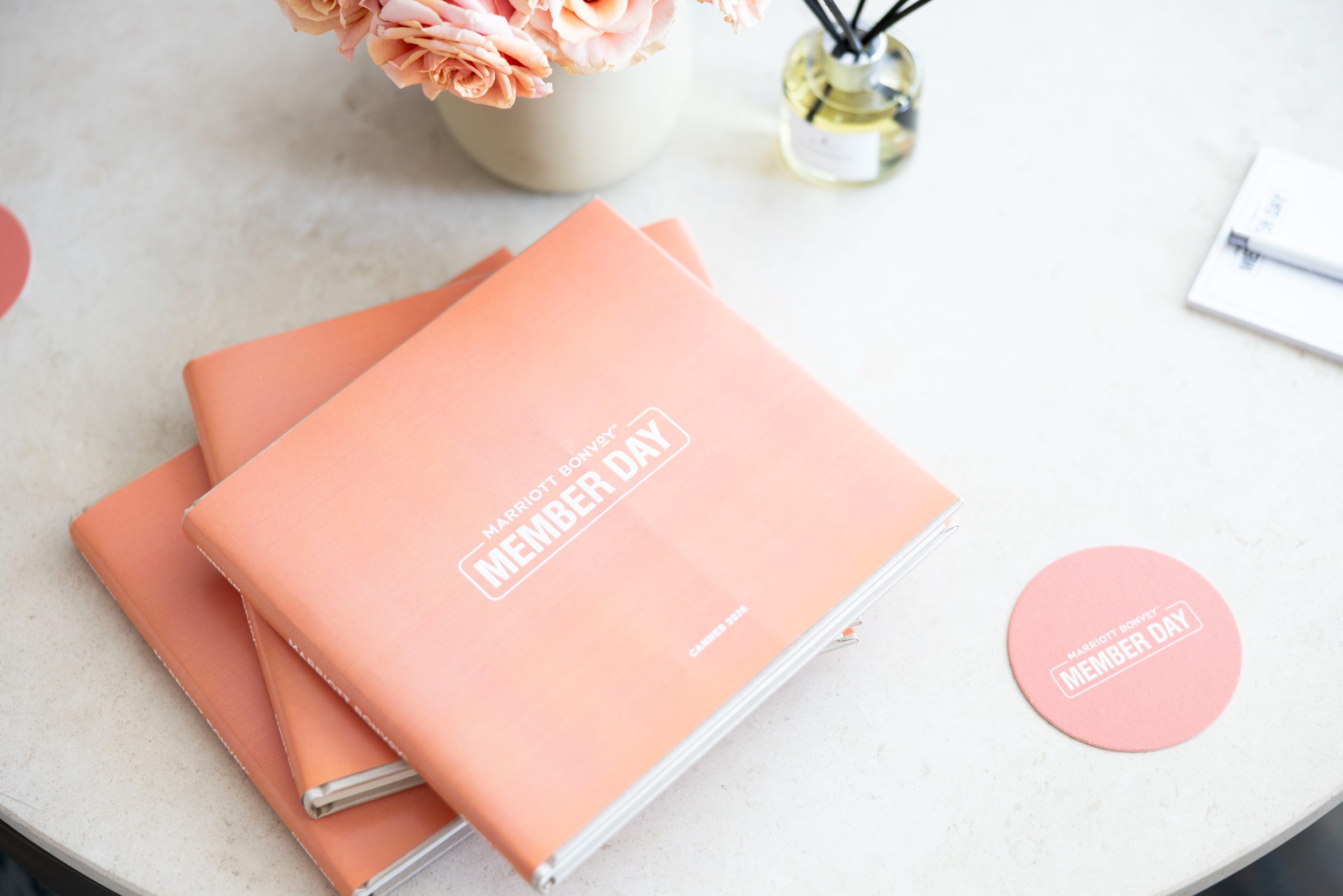 Peach Member Day books stacked on a table with a matching coaster