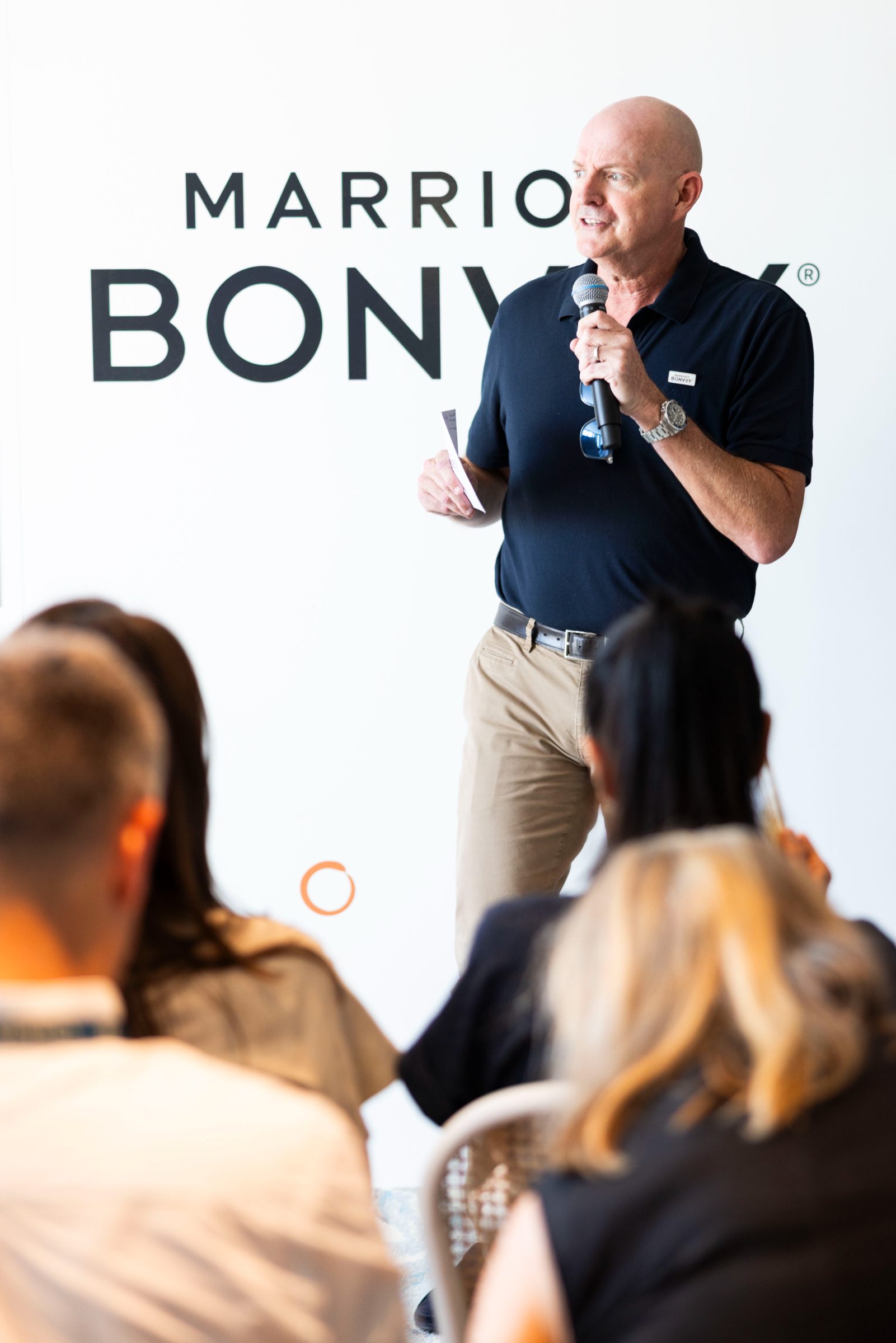 A speaker at the Marriott Bonvoy backdrop during Member Day