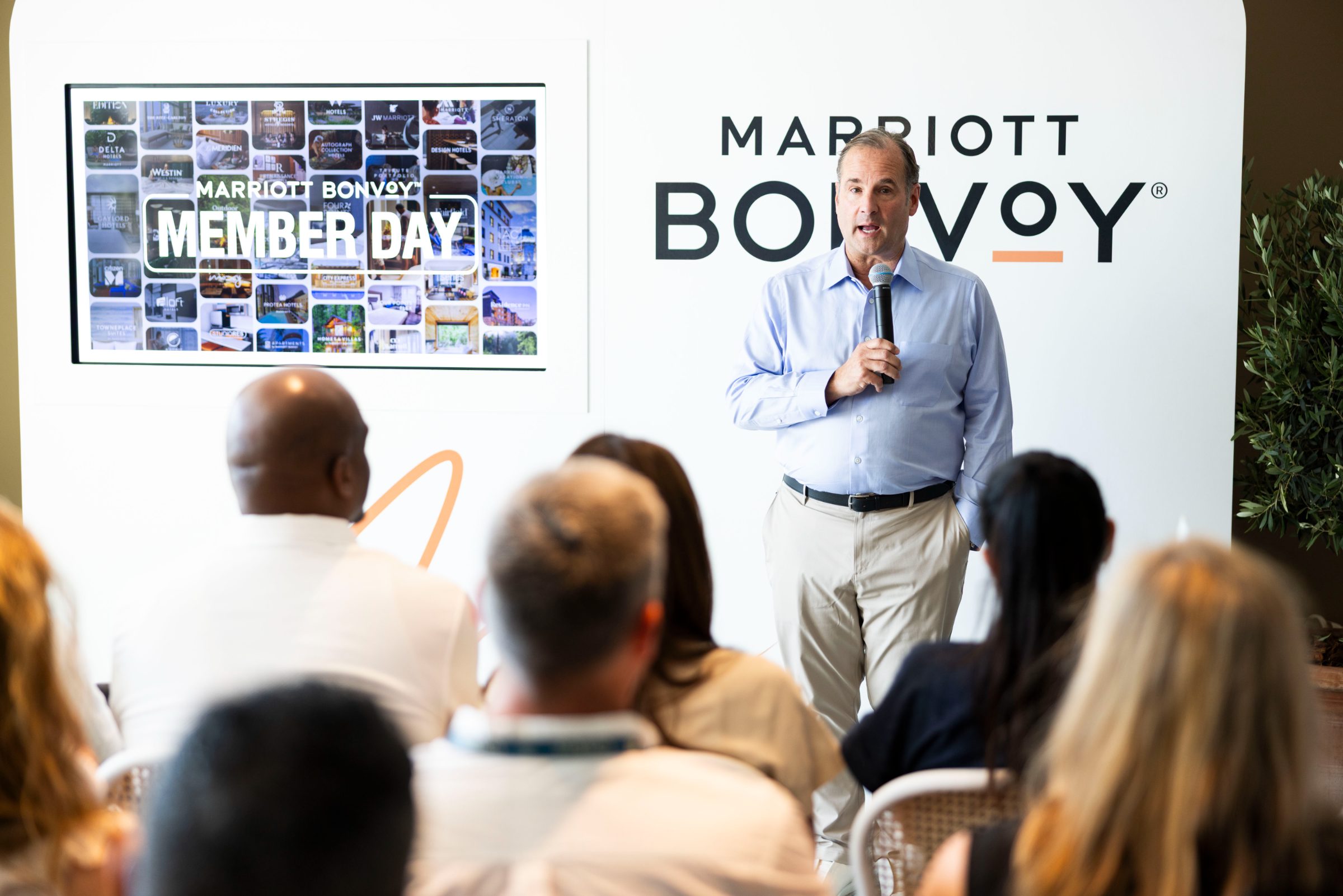 A speaker addressing members in front of the Marriott Bonvoy Member Day screen