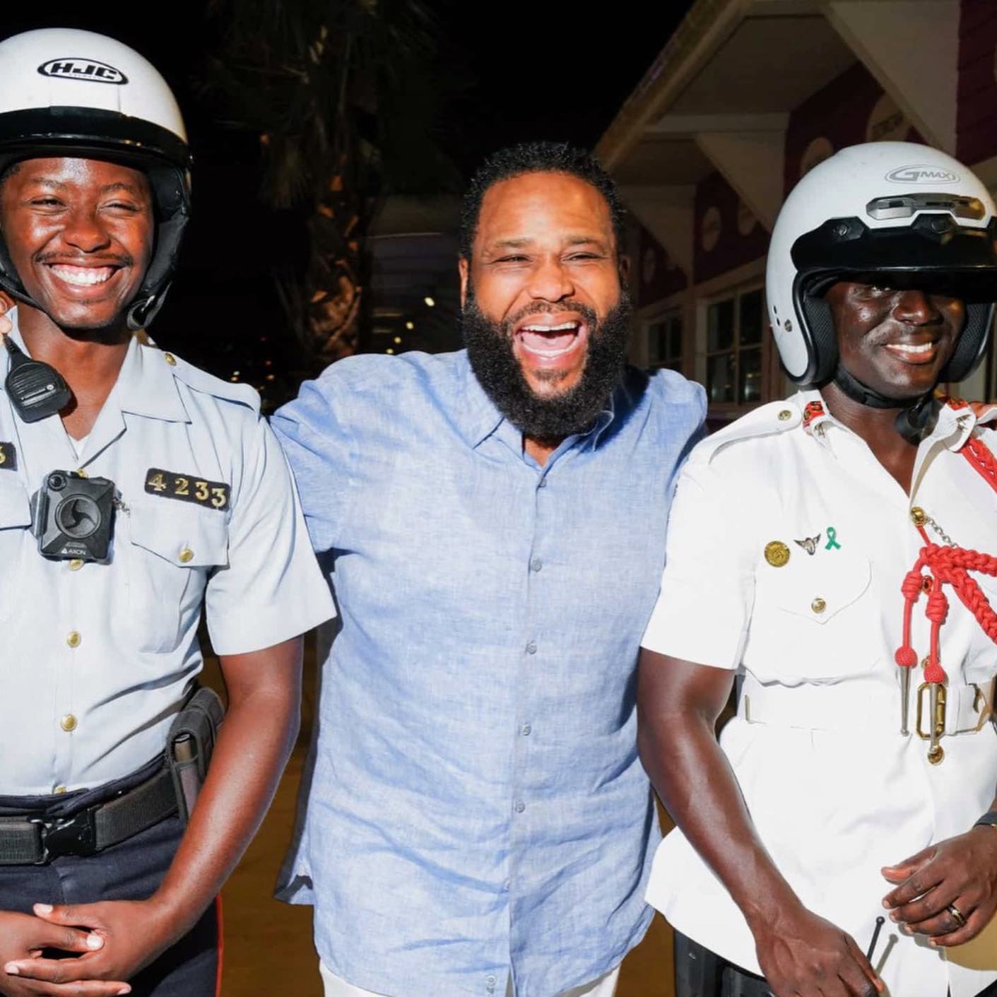 Anthony Anderson smiling with Bahamian police officers