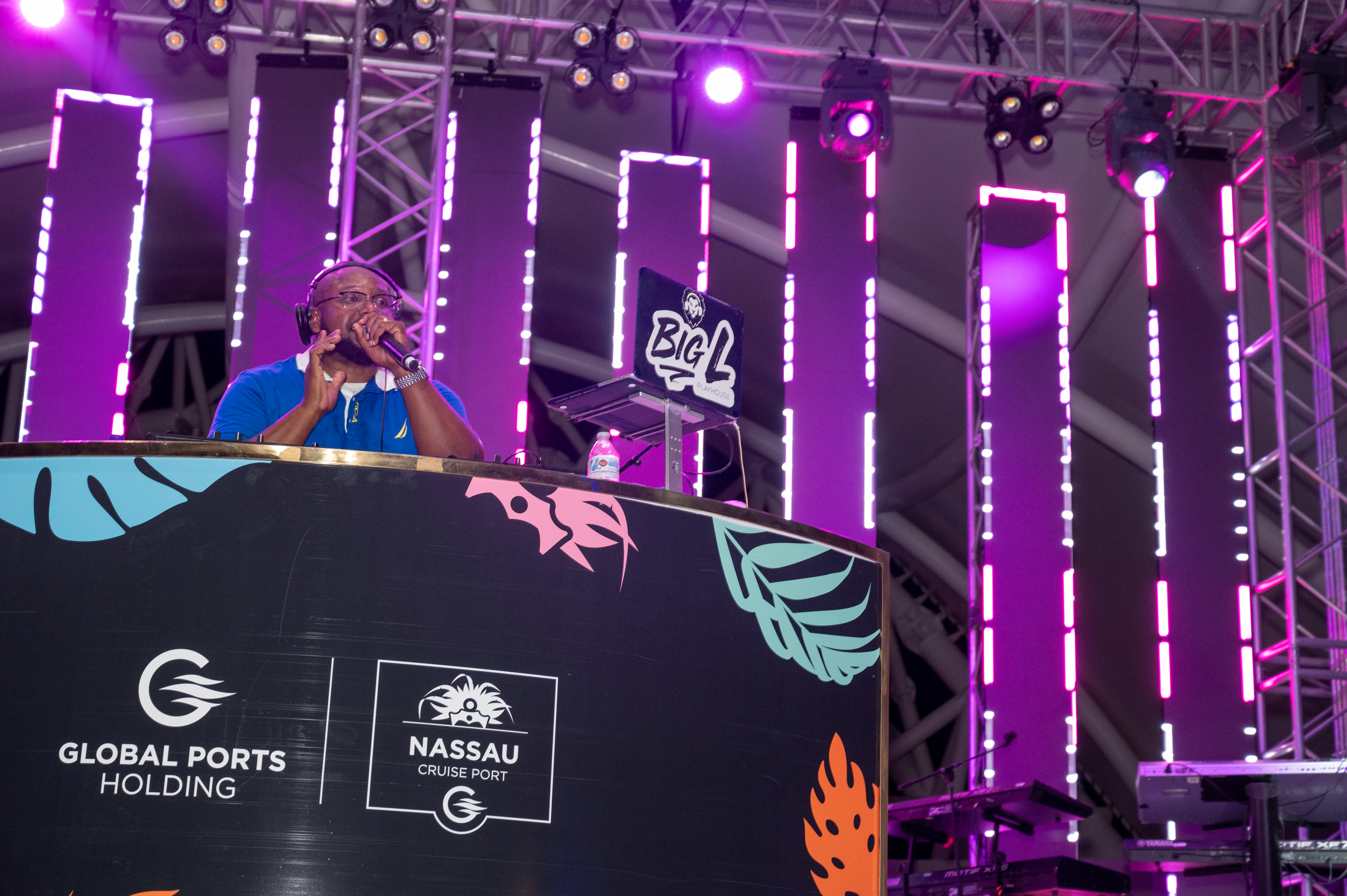 DJ performing behind the branded Nassau Cruise Port booth with animated LED panels